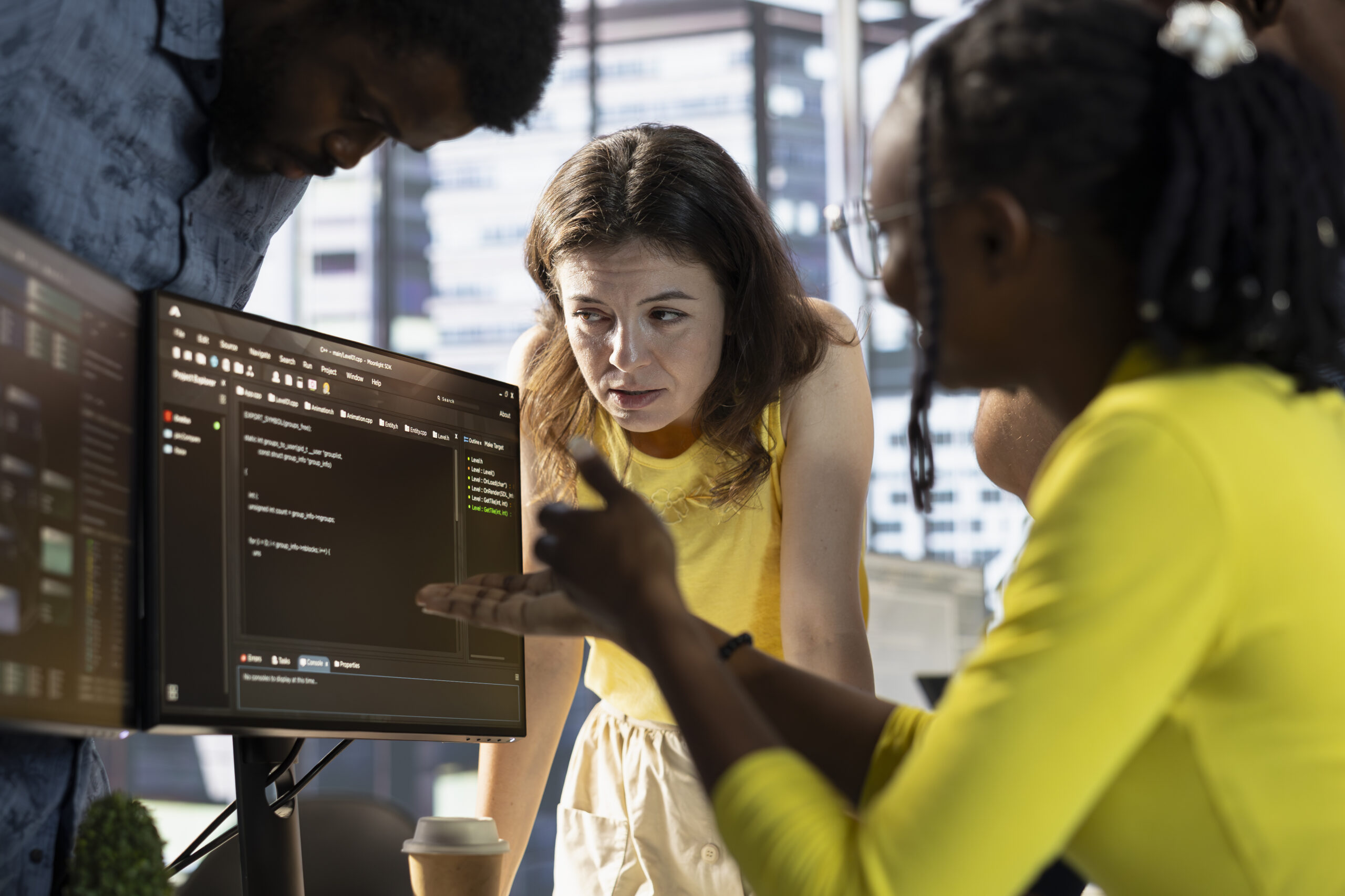IT staff members doing brainstorming, conducting tests in computer to optimize machine learning models for performance and accuracy. Team of developers talking in office, analyzing complex AI data